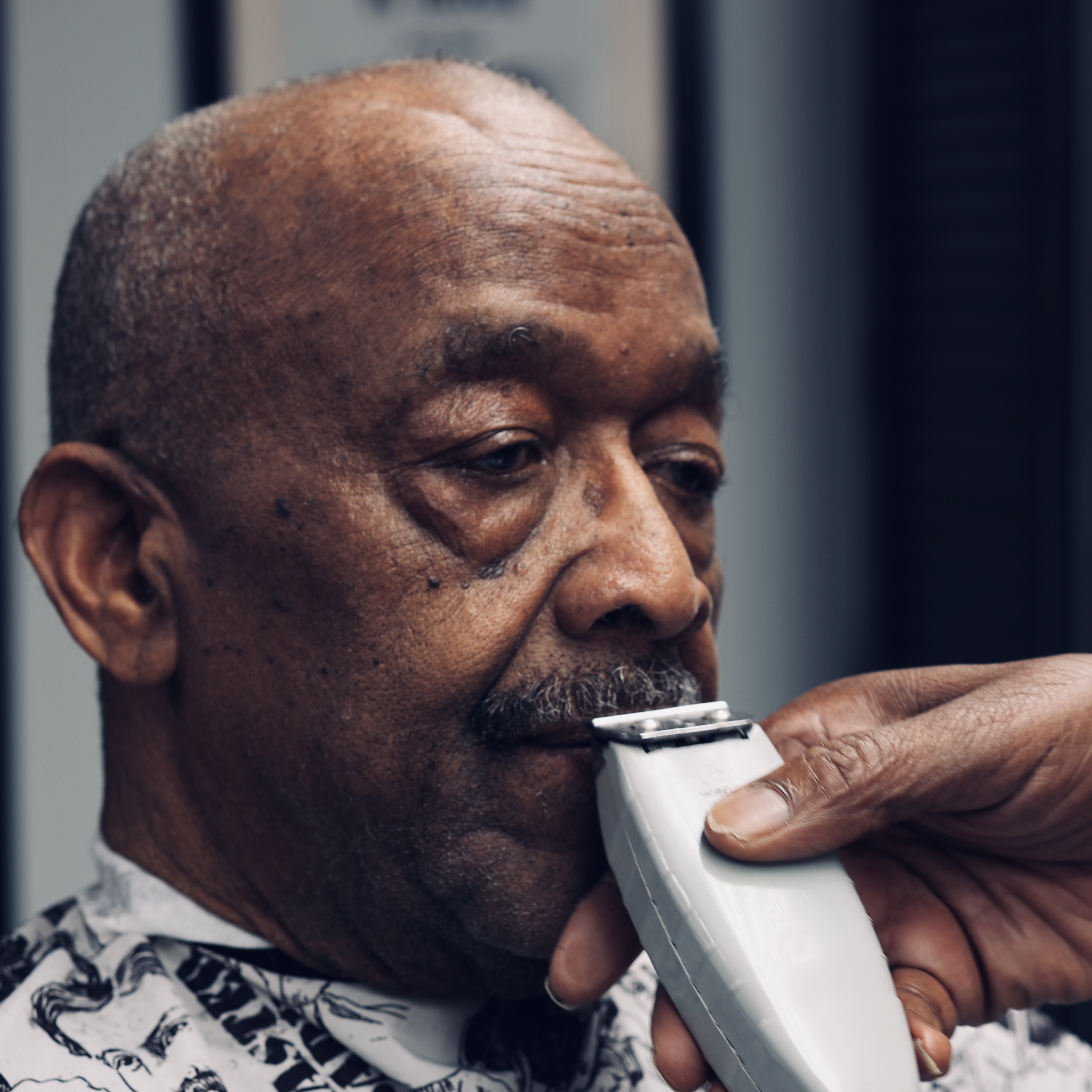 Barber at work, photographed by Captured by Kam